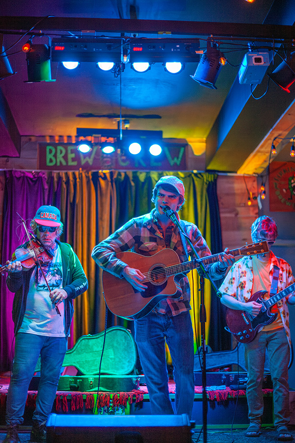 Local band performing live music on a small stage with colorful lights.