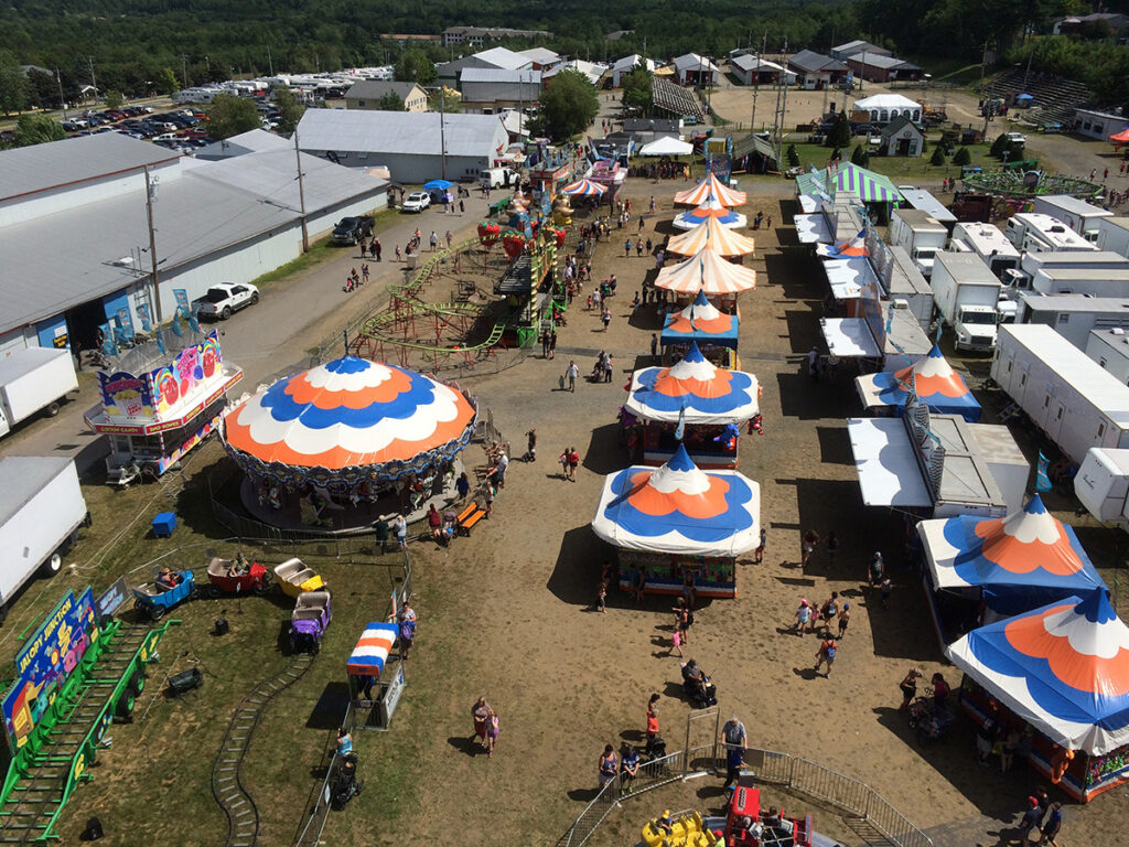 An aerial view of colourful tent alongside children's rides.