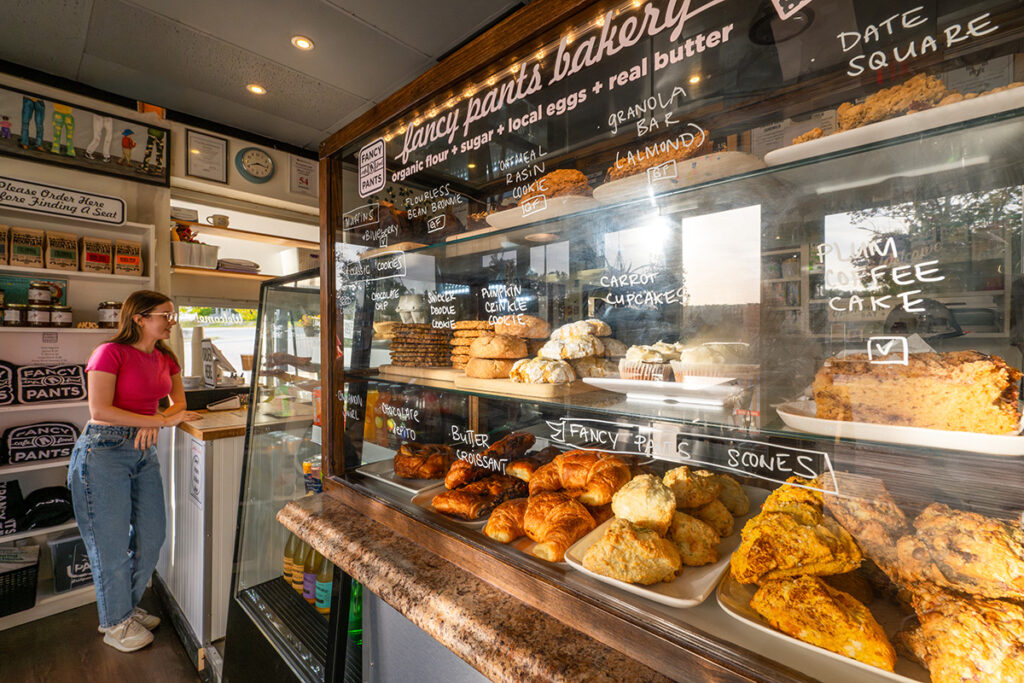Bakery display case with croissants, scones, cookies, and pastries at a local café.